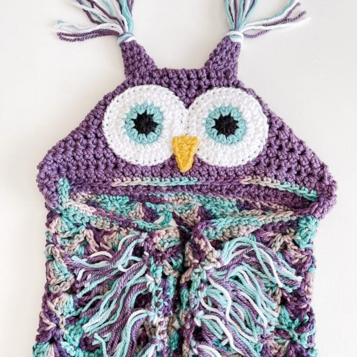 A crocheted owl hoodie with tassels.