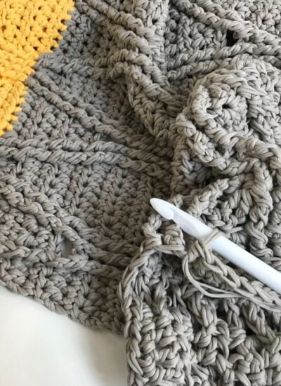A crochet blanket with a pen on top, perfect for snuggling under on chilly nights.