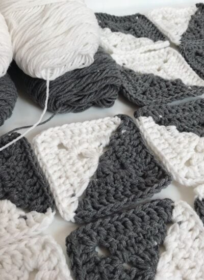 Free grey and white crocheted squares arranged on a table.