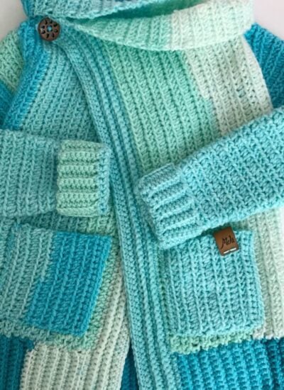 How to Make The Piece of Cake Cardi - A blue and white knitted cardigan with a hood.