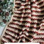 A crocheted granny blanket with brown, rust, and cream stripes is displayed next to eucalyptus leaves, pinecones, and Crochet Rustic Farmhouse Pumpkins. Text reads: "FALL FOR GRANNY BLANKET Free Crochet Pattern & Video.