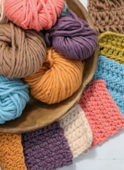 "Learn How to Crochet for Beginners with a bowl full of different colors of crocheted yarn.