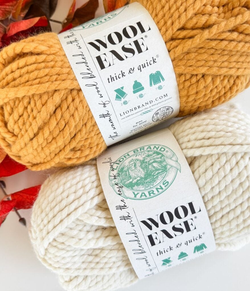 Two skeins of Lion Brand Wool-Ease Thick & Quick yarn in mustard yellow and cream, labeled and placed side by side—perfect for projects or as a reference in your yarn substitution guide.