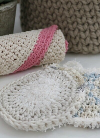A crocheted dishcloth with a potted plant on a table.