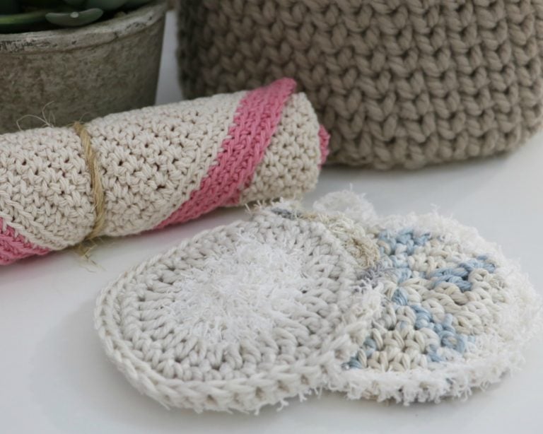 A crocheted dishcloth with a potted plant on a table.
