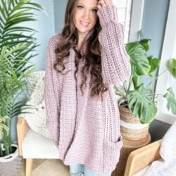 A woman wearing a pink Cuddly as a Cloud Cardigan.
