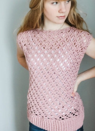 A young woman wearing a modern lace pullover in pink.
