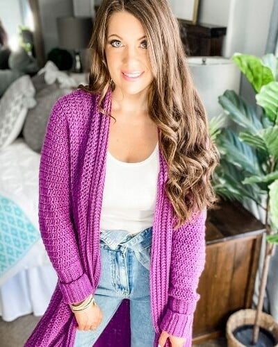 A woman wearing a mauve-a-lous duster cardigan and jeans.