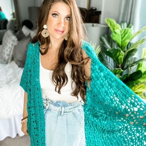 A woman wearing a turquoise Lacy Days Kimono and denim skirt.