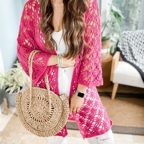 A woman wearing a pink crochet kimono.