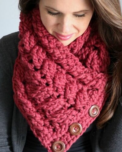 A woman wearing a red crochet boomerang shawl.