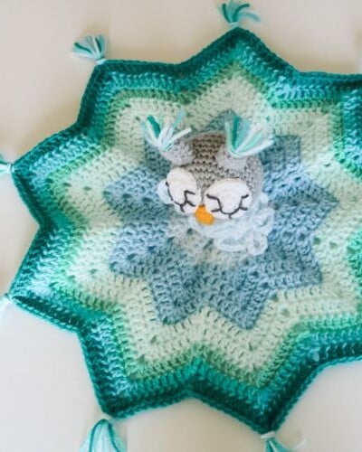 A crocheted owl swaddle blanket with tassels, perfect for your little one.
