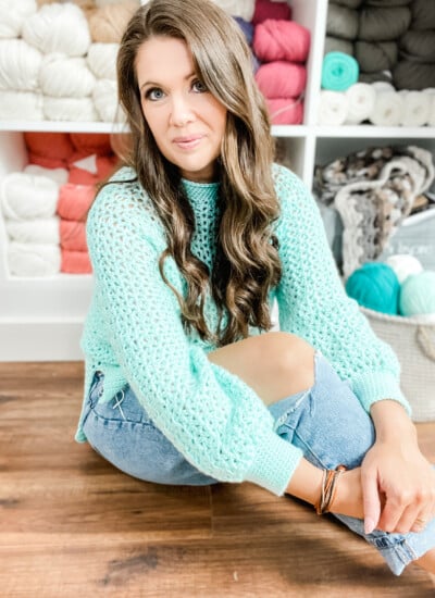 A beginner's guide to crochet featuring a woman surrounded by yarn.