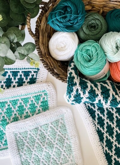 Crocheted Diamond Drift dishcloths and yarn in a basket.