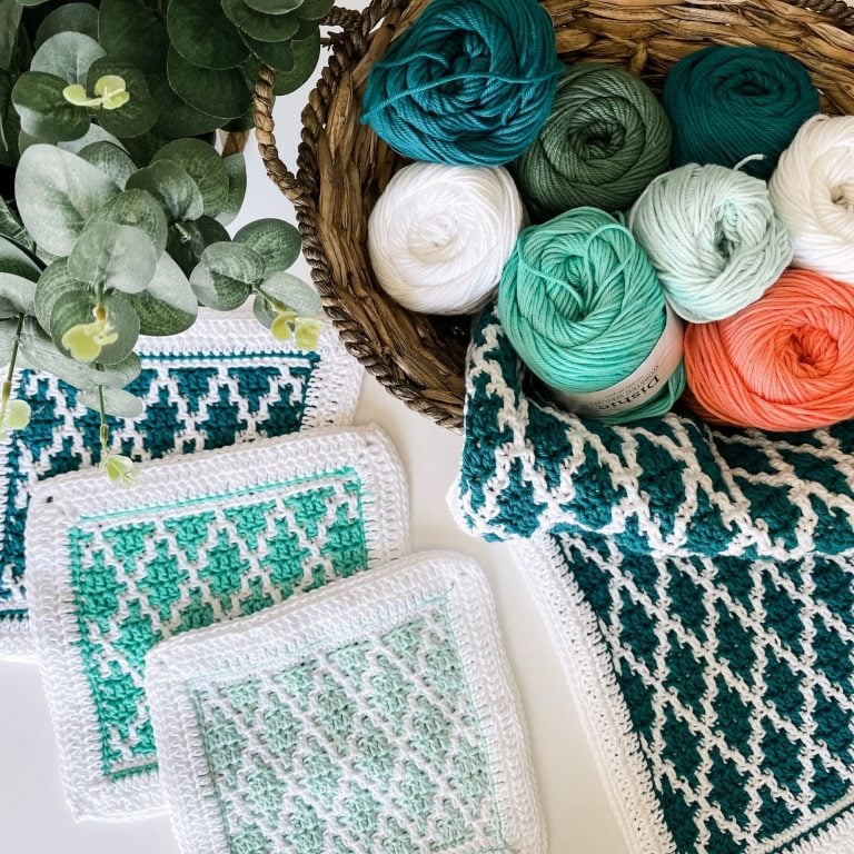 Crocheted Diamond Drift dishcloths and yarn in a basket.