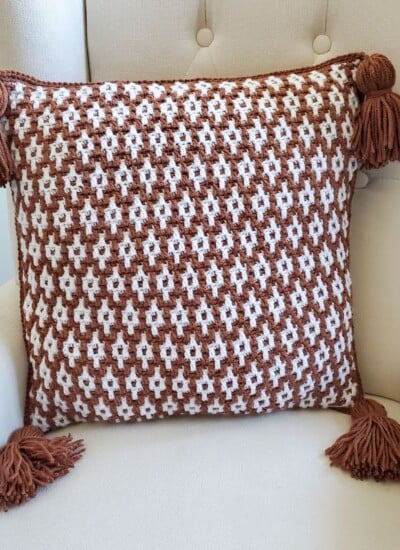 A Desert Dunes crocheted pillow with tassels.