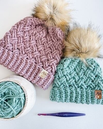 Description: Two bulky crocheted hats with pom poms and celtic-inspired yarn.