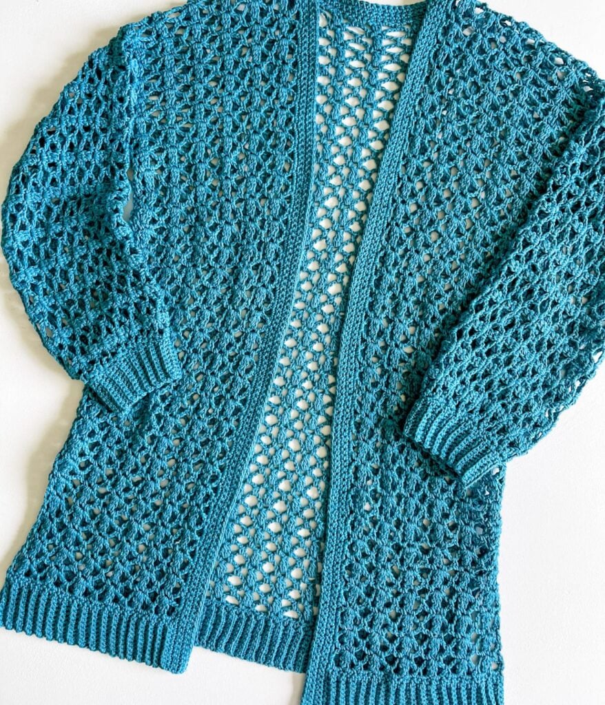 Teal Crochet Cabot Trail Cardigan with openwork pattern displayed on a white background.