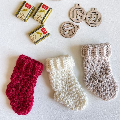 A set of mini crocheted stockings and a box of chocolates.