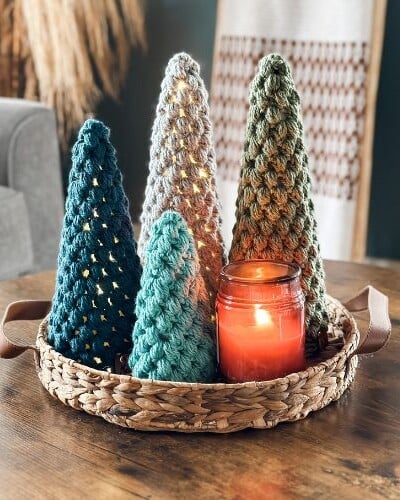 Crocheted puff stitch Christmas trees displayed in a wicker basket.