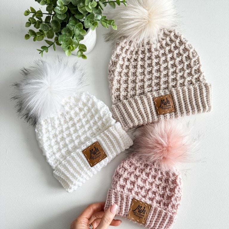 Three knitted hats with pom poms in Waffle Stitch.