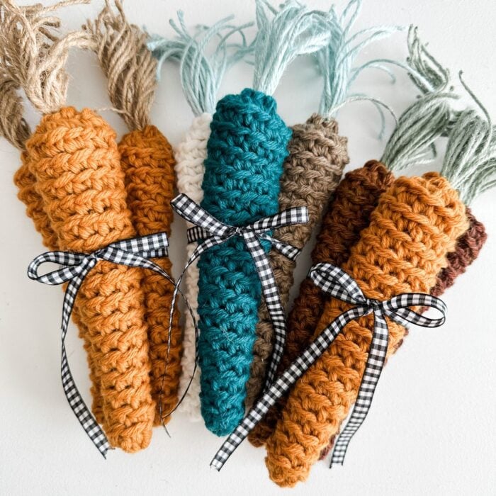 Four farmhouse carrots with ribbons tied around them.