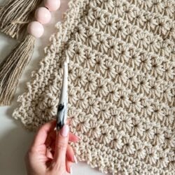 A person is knitting a crocheted Star Stitch crochet Blanket.
