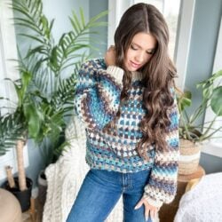 A woman wearing a crochet sweater.