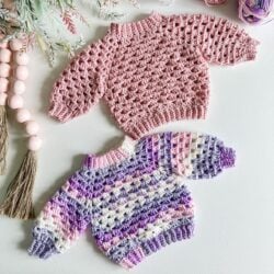 Two top-down crocheted sweaters on a white table.