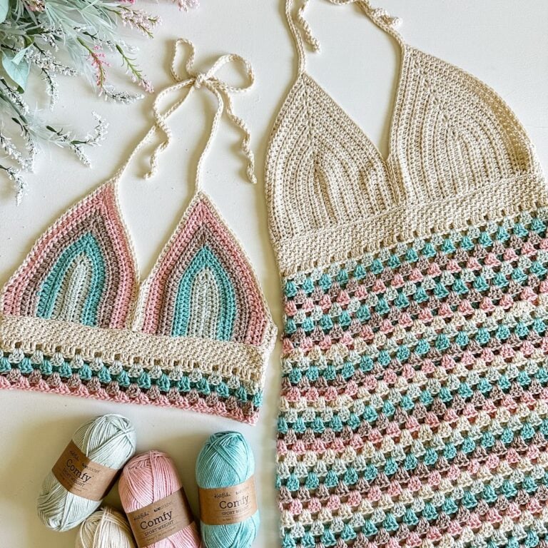 A crocheted bikini set with yarn and knitting needles. The set includes a crochet halter top.