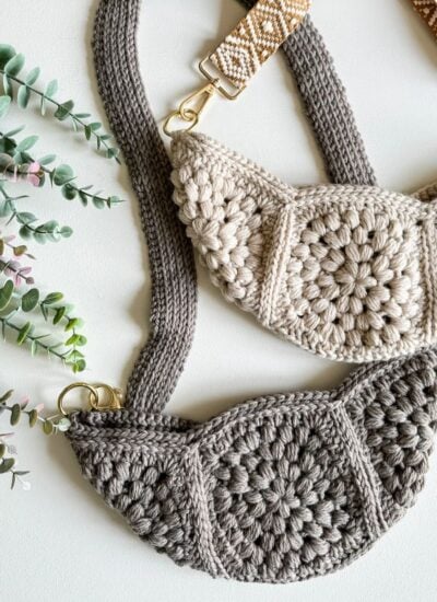 Two crochet bags on a table next to a plant.