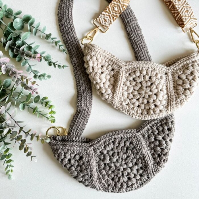 Two crochet bags on a table next to a plant.