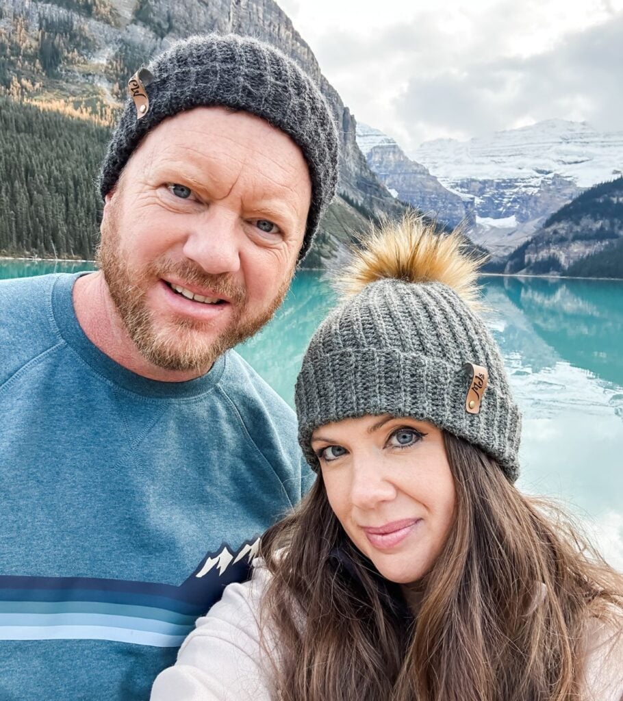 A man and woman posing for a selfie in front of a lake, both wearing Rocky Ridge Crochet Hats.