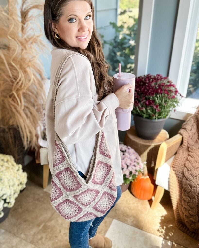 Lady modelling granny square crochet bag