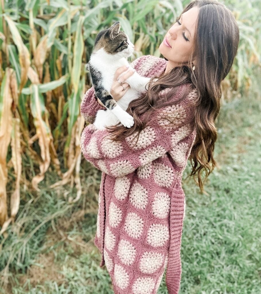 Lady Modelling Granny Square Coatagin with cat 