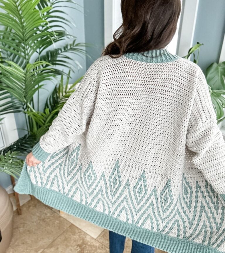 The back view of a woman wearing a knit cardigan.