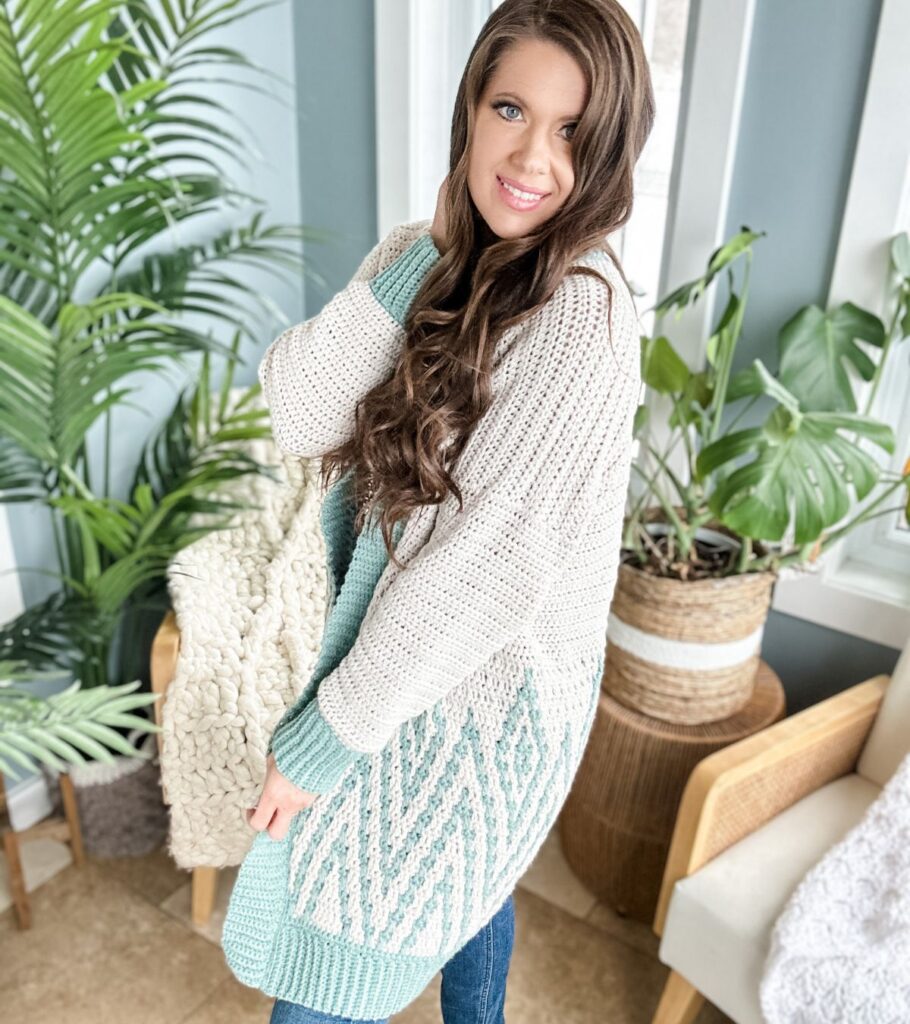 A woman wearing a cardigan sweater and a pair of jeans.