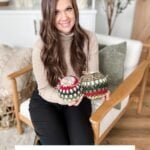 A woman sits on a chair holding two crocheted holiday baubles, each crafted in the style of a Granny square ornament. Text at the bottom reads "Holiday Weave Baubles Crochet Pattern & Video.