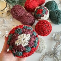A person holding a bunch of crochet balls.