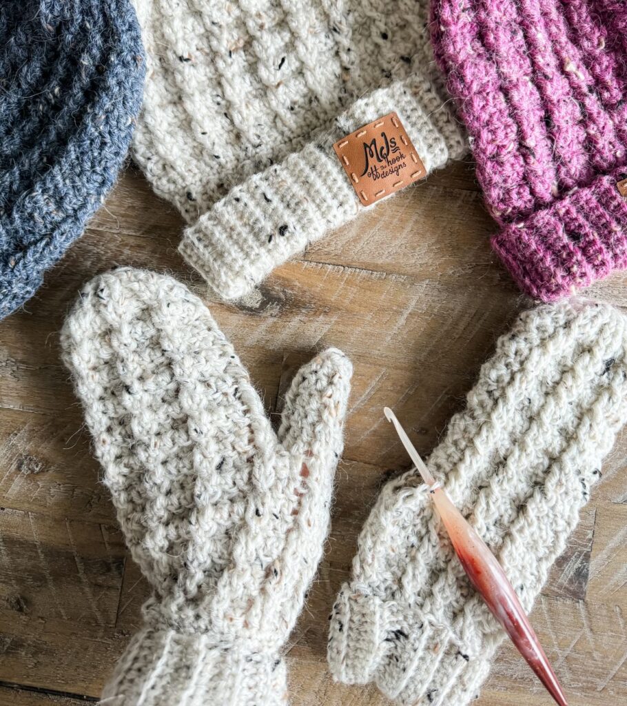 Crocheted mittens on a wooden table.