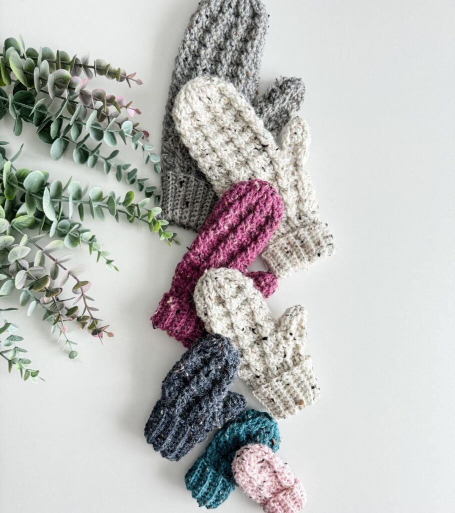 Crocheted mittens on white surface.