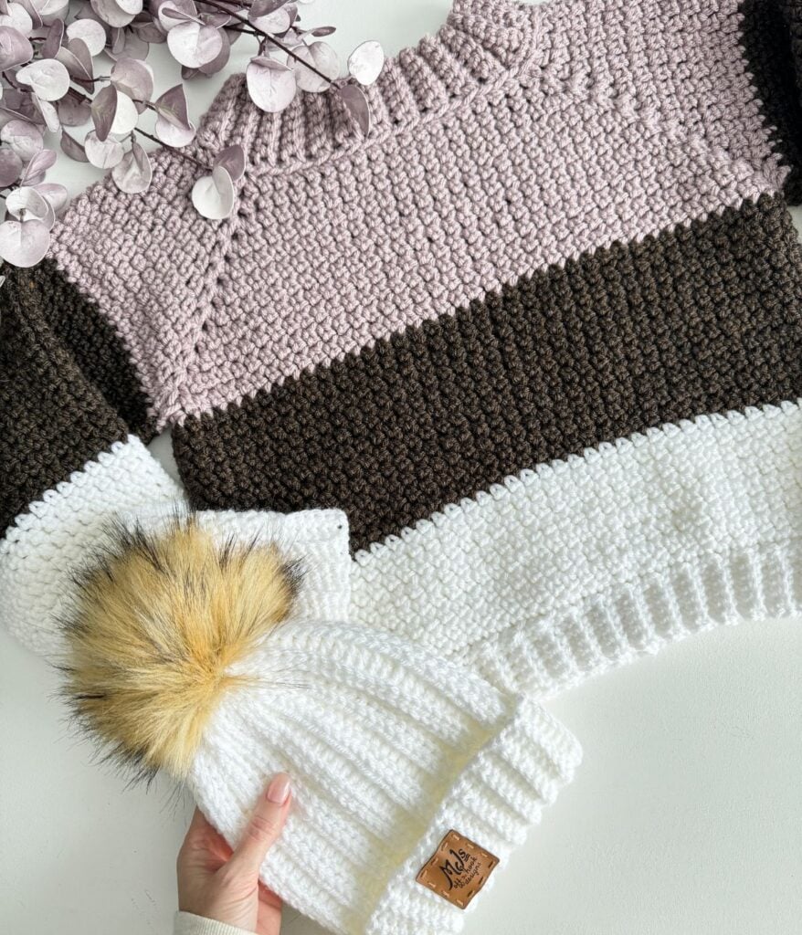 A children's pullover with a fur pom pom.