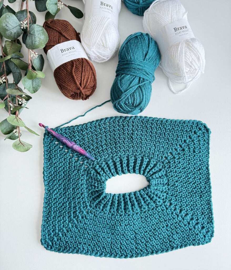 A crocheted raglan yoke with yarn and a Furls crochet hook