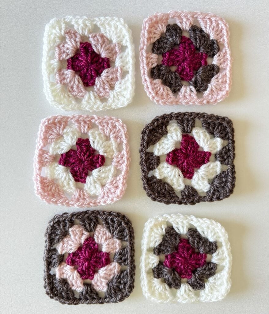 Six crochet granny squares in assorted color combinations arranged in two rows on a light background.