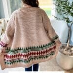 A person wearing a mosaic crochet cardigan stands indoors near a window and a potted plant. Text at the bottom reads, "Top-Down & Seamless Mosaic Cardigan Crochet Pattern XS-5X plus Video Tutorial.