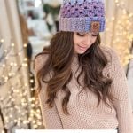 A woman models a purple and blue chunky crochet hat with a pom-pom, accompanied by text reading "Easy Chunky Granny Hat: Free Pattern + Video.