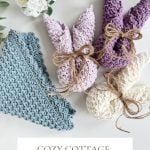 Three crochet bunny-shaped dishcloths tied with twine and one blue triangle Crochet Dishcloth are arranged near white flowers on a white surface. Text reads: Cozy Cottage Dishcloth, crochet pattern & video.