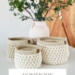 Three cream-colored crochet baskets are displayed in front of a white vase with white flowers and greenery on a light surface. Text reads: “Homebody Baskets: Crochet Basket Pattern & Video, Bulky & Quick.”.