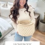 Woman with long brown hair holds a chunky crochet basket in a cozy, well-lit room. Text below reads: “Homebody Baskets: Crochet Basket Pattern & Video, Bulky & Quick.”.