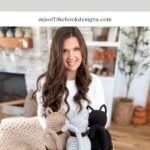 A woman sits indoors holding a basket with three crochet cats in neutral colors. Text above reads "Rustic Farmhouse Crochet Cat Pattern & Video.
